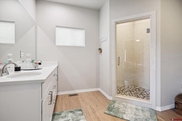 bathroom featuring an enclosed shower, hardwood / wood-style floors, and vanity with extensive cabinet space