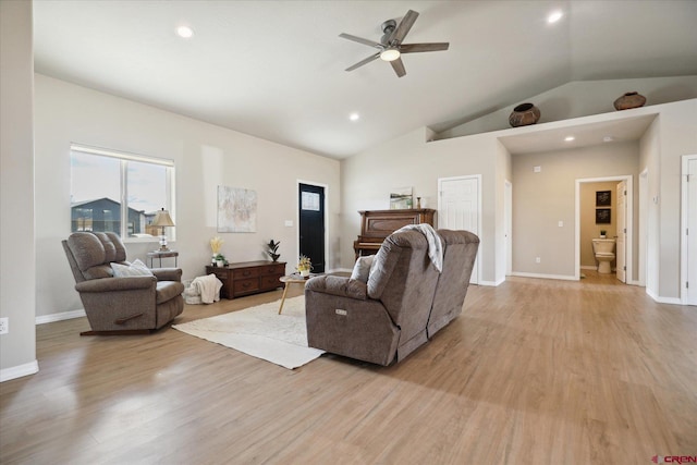 living room featuring ceiling fan, vaulted ceiling, and light hardwood / wood-style floors