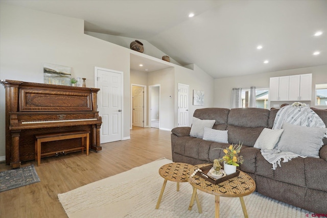 living room featuring lofted ceiling and light hardwood / wood-style floors