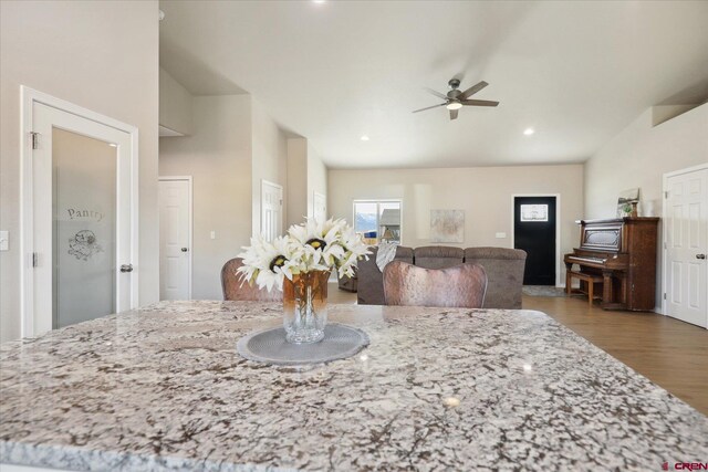 kitchen with light stone countertops, ceiling fan, hardwood / wood-style flooring, and white cabinetry