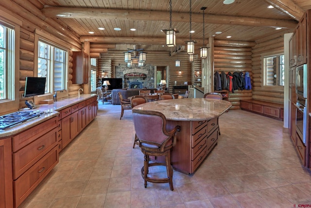 kitchen with rustic walls, light stone countertops, a fireplace, wood ceiling, and pendant lighting