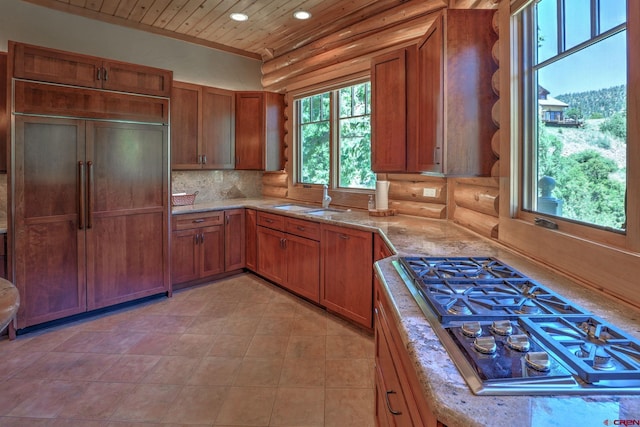 kitchen featuring log walls, sink, light tile floors, and tasteful backsplash