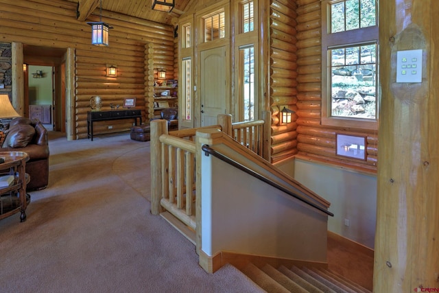 staircase featuring rustic walls, light carpet, a high ceiling, and wooden ceiling