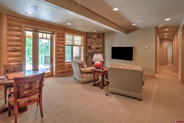 living room with rustic walls, light carpet, and a fireplace