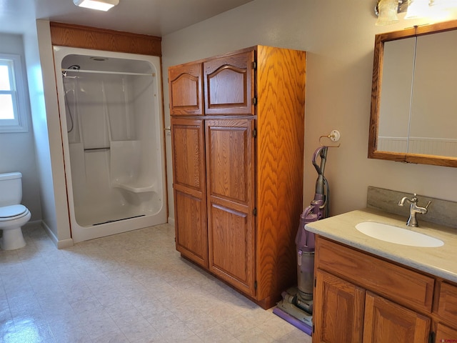 bathroom featuring walk in shower, tile flooring, oversized vanity, and toilet