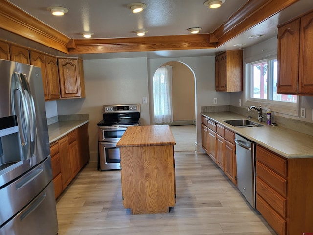 kitchen with sink, appliances with stainless steel finishes, a center island, butcher block counters, and light wood-type flooring