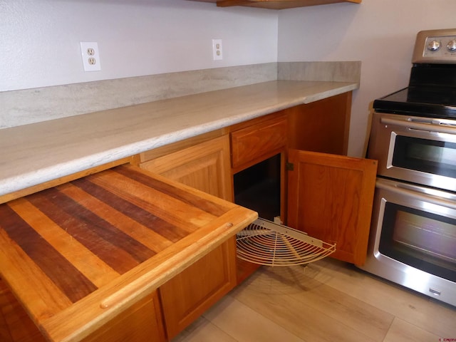 kitchen with butcher block countertops, light hardwood / wood-style floors, and double oven range