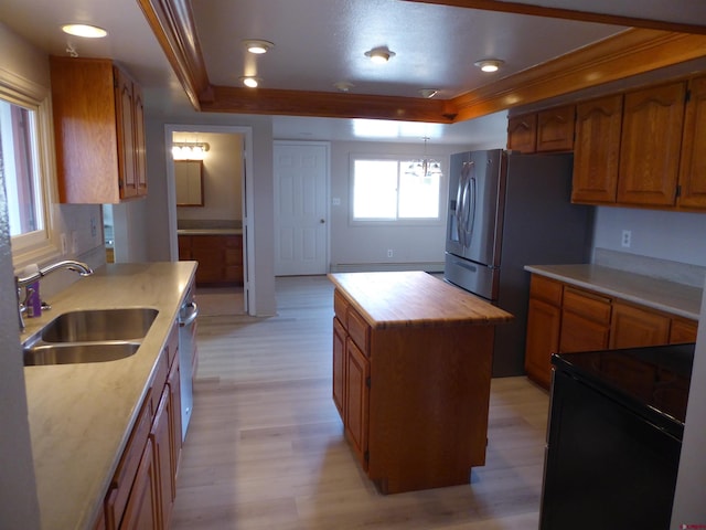 kitchen featuring decorative light fixtures, sink, light hardwood / wood-style flooring, wood counters, and a kitchen island