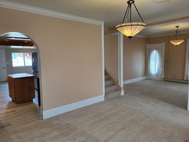 carpeted spare room with a baseboard heating unit and crown molding