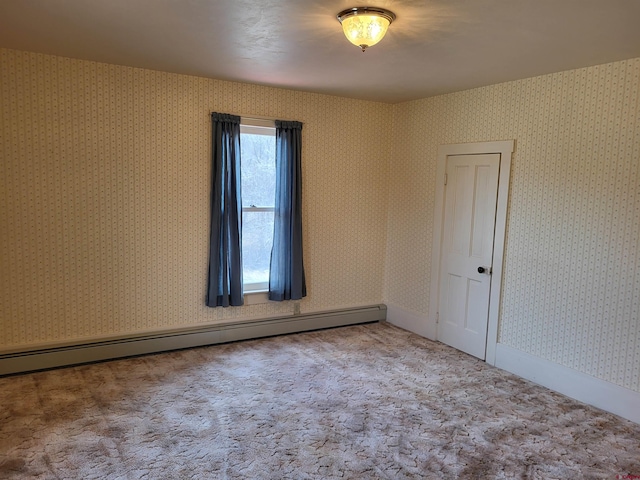 carpeted empty room featuring baseboard heating