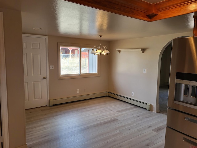 unfurnished room with light hardwood / wood-style flooring, a notable chandelier, and a baseboard heating unit