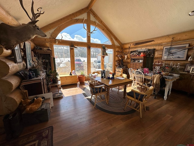 living room featuring log walls, a textured ceiling, high vaulted ceiling, dark wood-type flooring, and beam ceiling