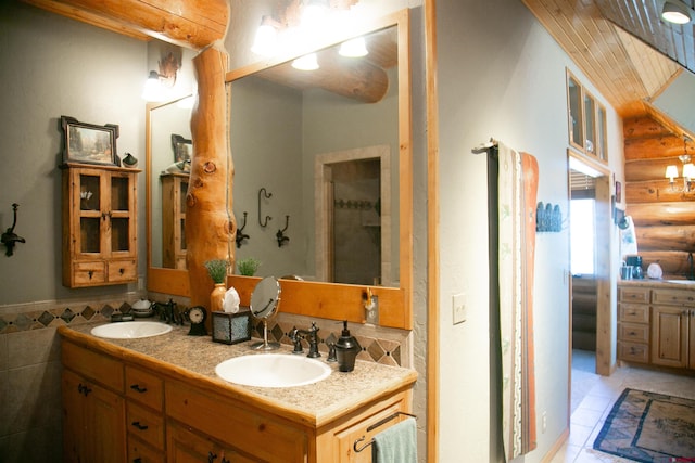 bathroom with tile walls, dual sinks, log walls, a shower, and oversized vanity