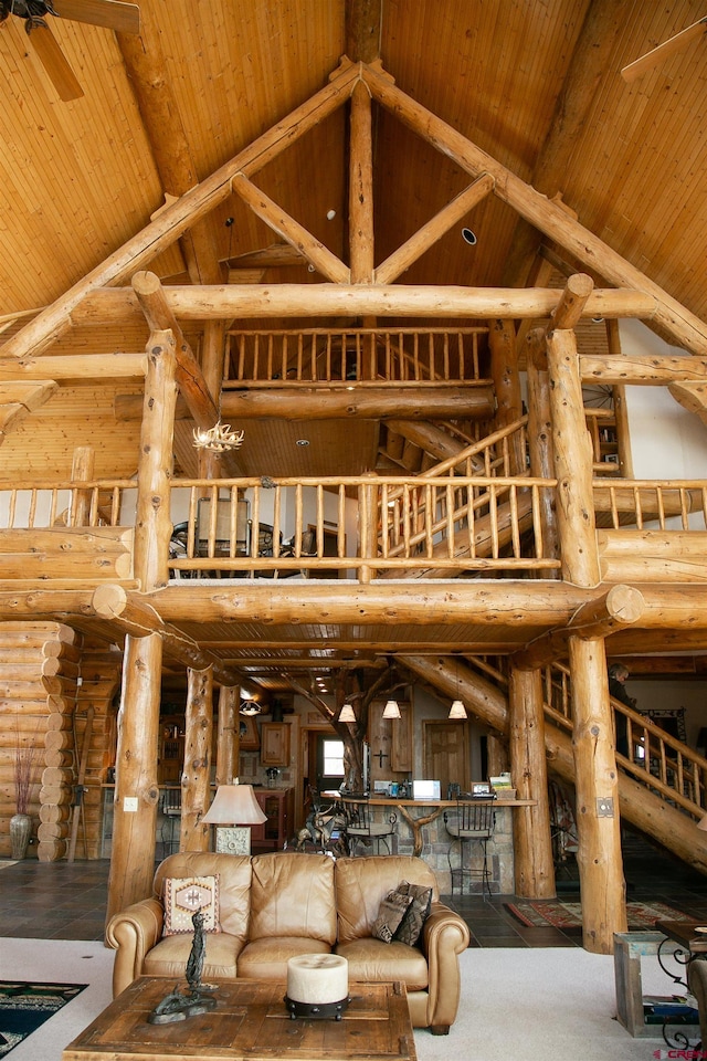 living room featuring high vaulted ceiling, hardwood / wood-style flooring, rustic walls, and ceiling fan