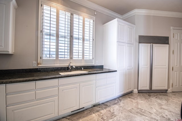 kitchen featuring light tile flooring, sink, ornamental molding, and white cabinets