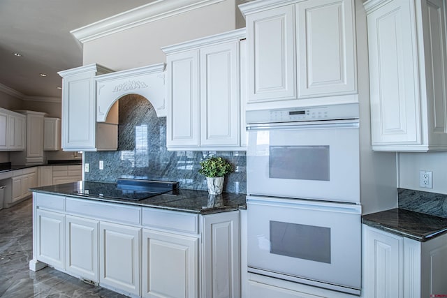 kitchen featuring double oven, backsplash, and white cabinetry