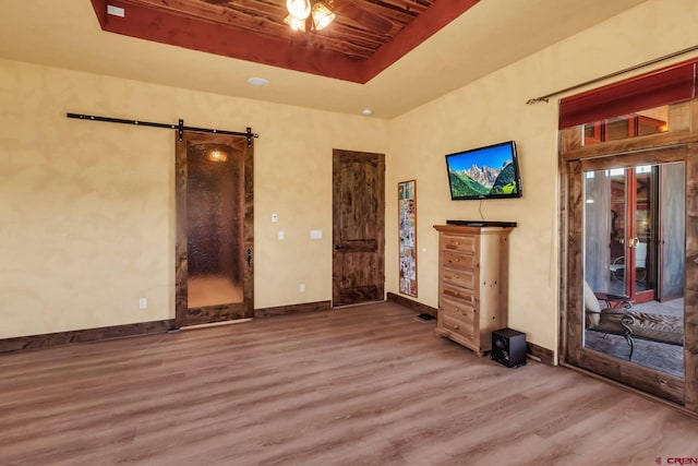 interior space with a barn door and dark hardwood / wood-style floors