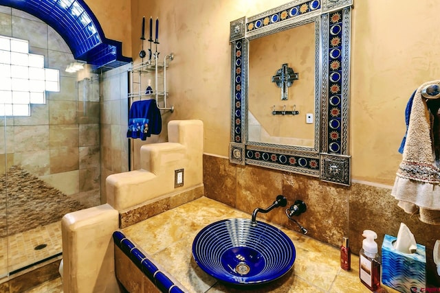 bathroom with tile walls, tile flooring, and tiled shower