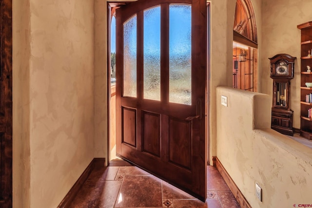 foyer featuring dark tile flooring