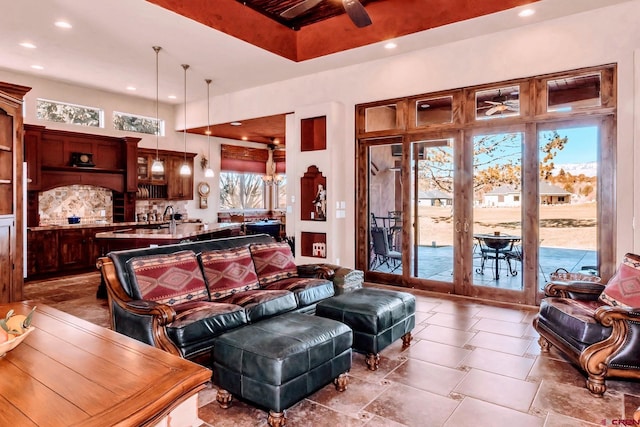 living room with ceiling fan, tile flooring, french doors, and sink