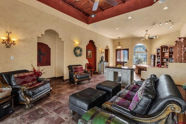 living room featuring dark tile floors, rail lighting, and ceiling fan