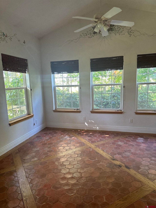 tiled empty room featuring ceiling fan and vaulted ceiling