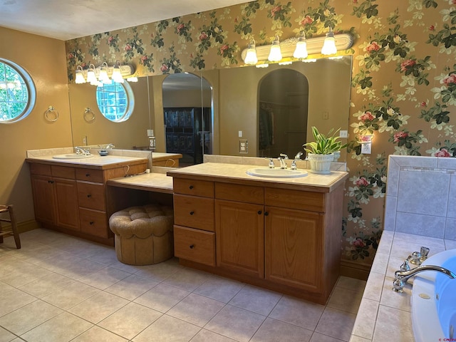 bathroom featuring tile flooring, a bath, and vanity