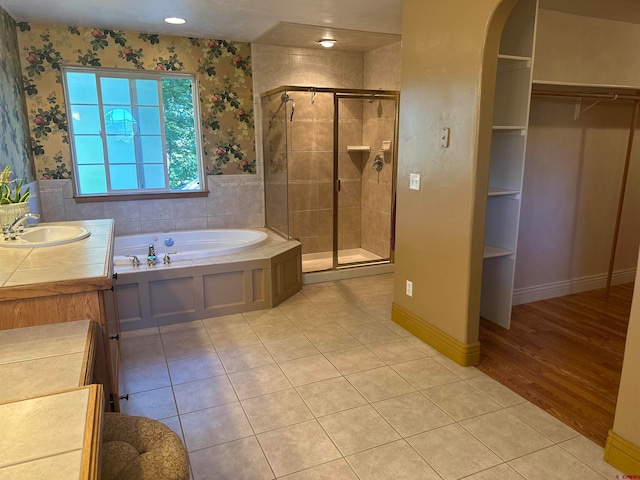 bathroom featuring vanity, plus walk in shower, and wood-type flooring