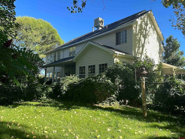 rear view of house featuring a lawn