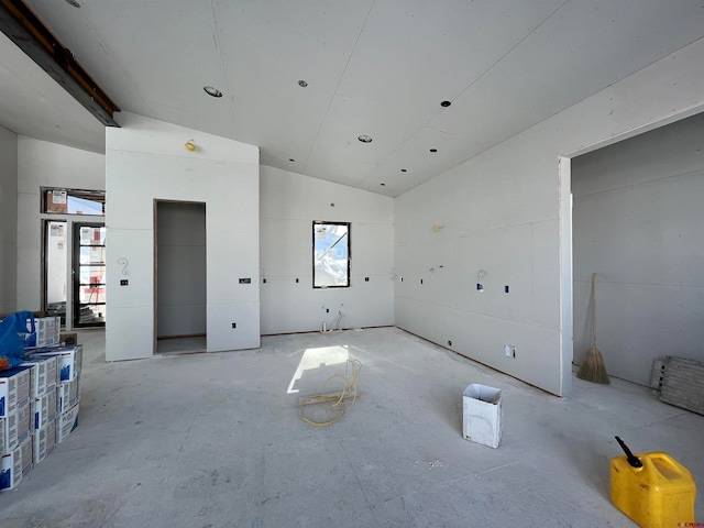 empty room with elevator and vaulted ceiling