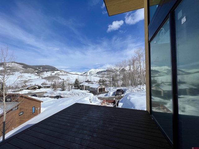 snow covered back of property with a mountain view