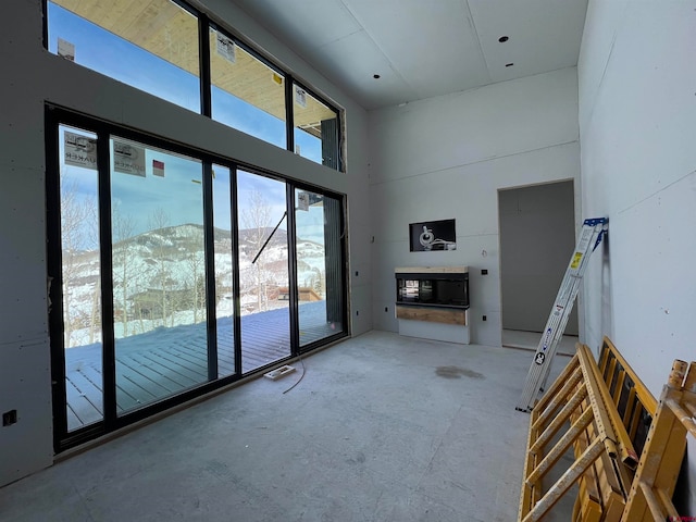 unfurnished living room with a high ceiling and a mountain view