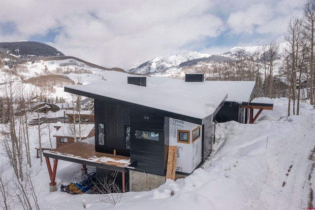 snow covered house featuring a mountain view