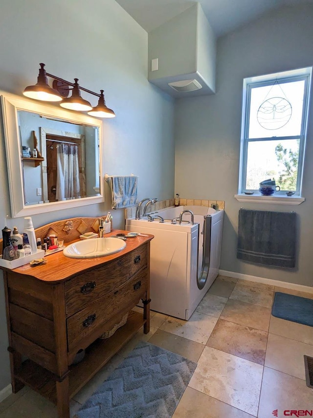 bathroom featuring a bath to relax in, tile floors, and oversized vanity