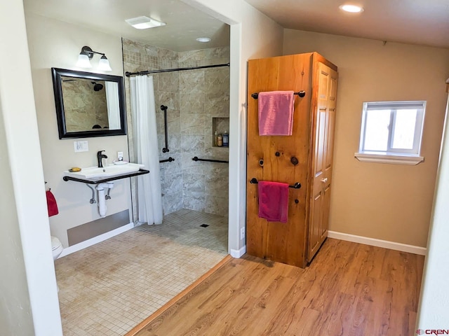 bathroom featuring curtained shower, toilet, sink, and hardwood / wood-style flooring