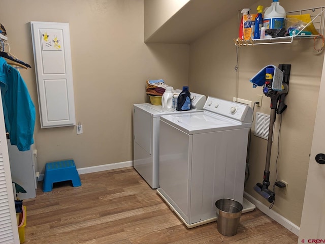 laundry area featuring washer and clothes dryer and light hardwood / wood-style flooring