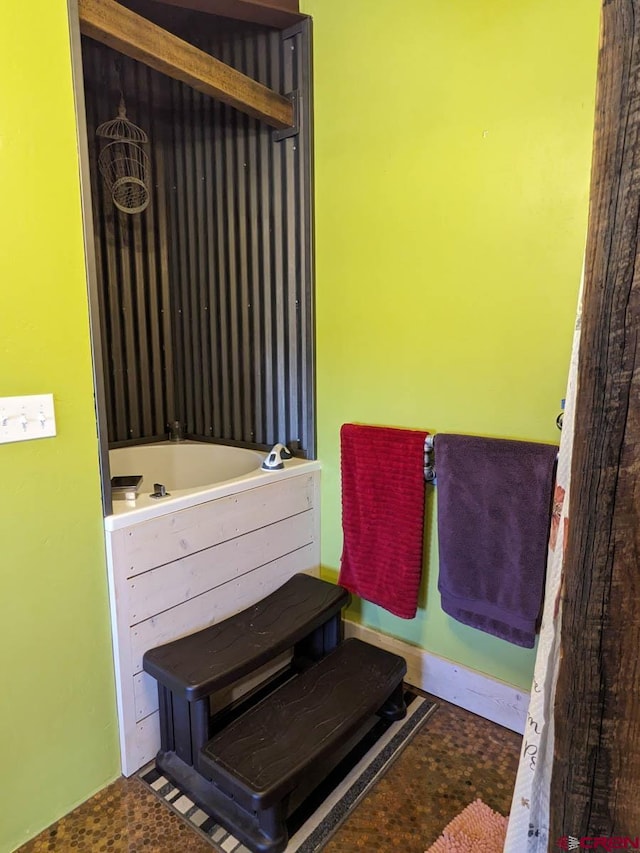 bathroom with a tub and tile flooring