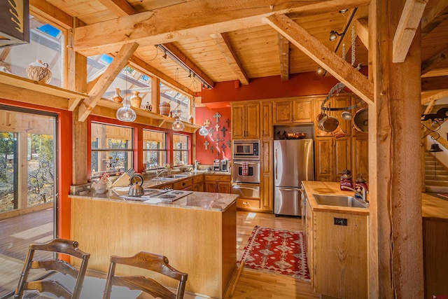 kitchen with sink, stainless steel appliances, light wood-type flooring, and wooden ceiling