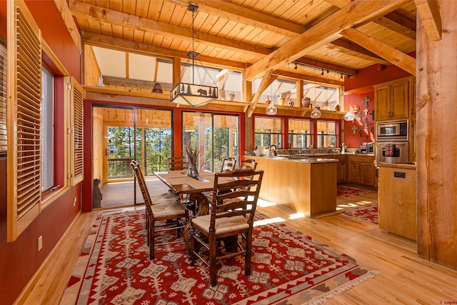 dining space featuring light wood-type flooring, wood ceiling, and beamed ceiling