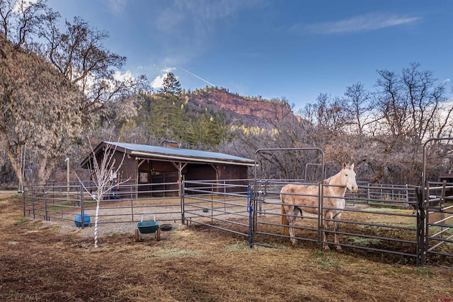 view of horse barn featuring a rural view and an outdoor structure