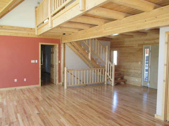 spare room featuring beam ceiling, light hardwood / wood-style floors, and wood ceiling