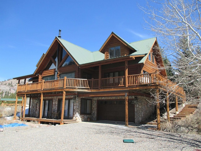 rear view of house featuring a balcony and a garage