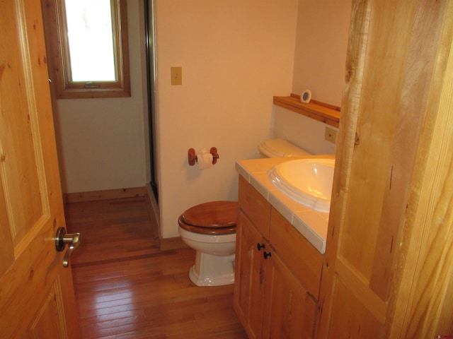 bathroom with toilet, vanity, and hardwood / wood-style flooring