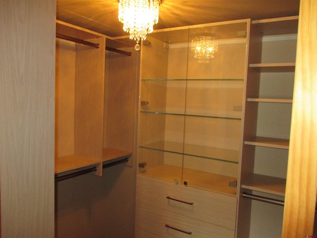 walk in closet featuring a notable chandelier