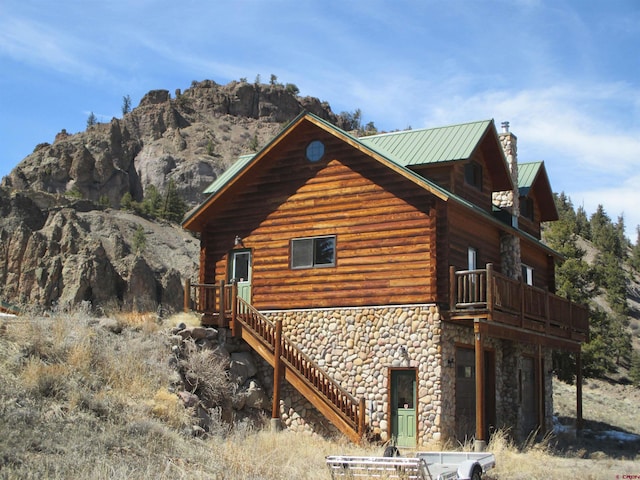 view of property exterior with a balcony and a mountain view