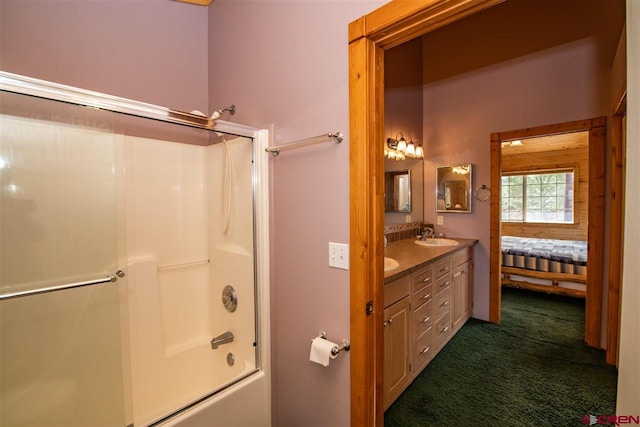 bathroom featuring dual vanity and bath / shower combo with glass door