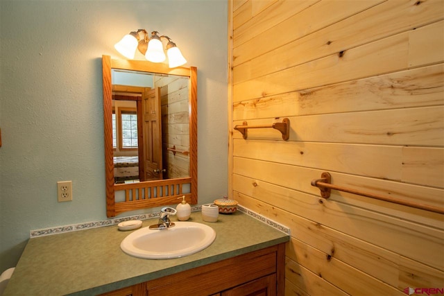 bathroom featuring wooden walls and large vanity