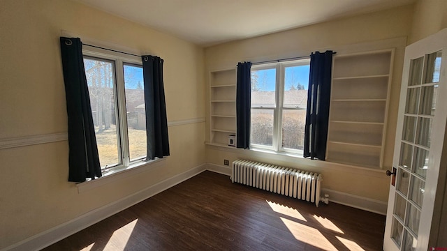 empty room featuring dark hardwood / wood-style floors and radiator