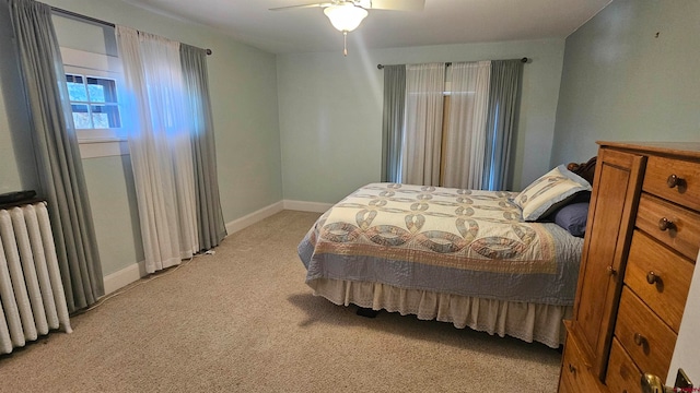 carpeted bedroom featuring ceiling fan and radiator heating unit