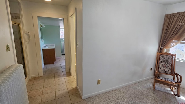 living area featuring light tile patterned floors and radiator heating unit